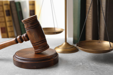 Wooden gavel, scales of justice and books on table. Law concept