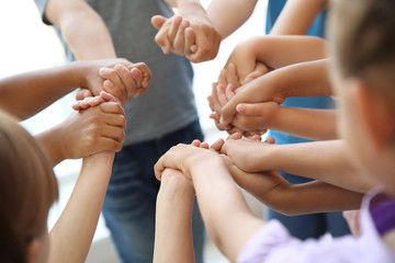 Little children holding their hands together, closeup. Unity concept