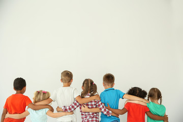 Little children hugging each other with hands on light background. Unity concept