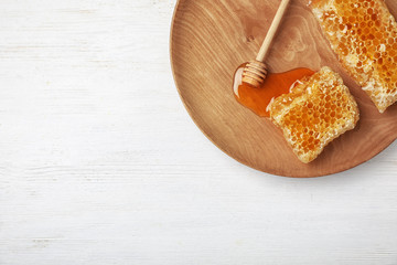 Flat lay composition with fresh honeycombs and dipper on wooden background