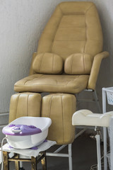 Convenient leather chair for the client on services of a pedicure from a bathroom for legs