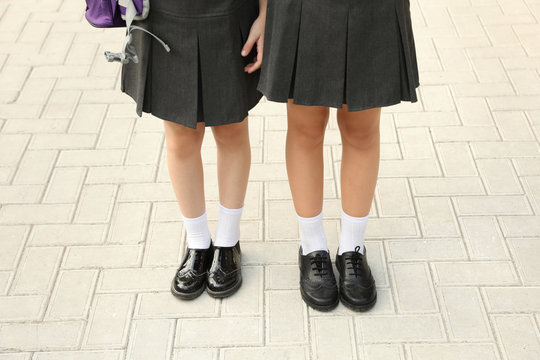 Girls in stylish school uniform outdoors, focus on legs