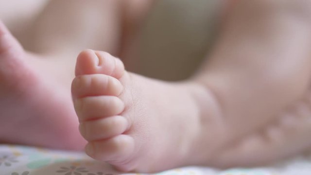 Close -up shot of active baby moving little bare feet