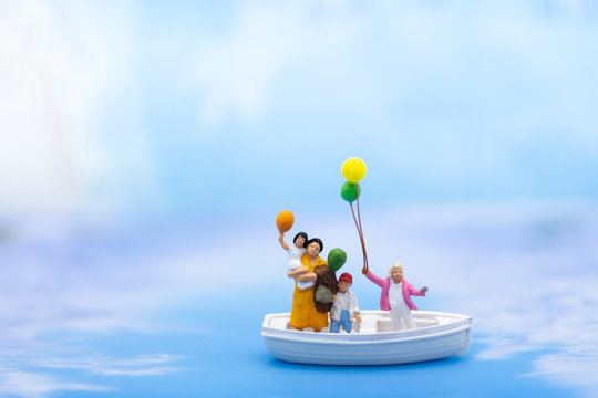 Miniature family, standing on boat in the ocean. Image use for family day, holiday concept.
