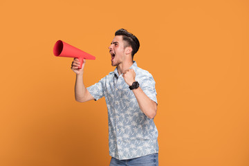 Handsome man shouting by megaphone.