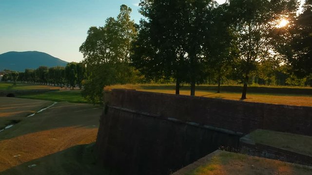 Sunset telephoto shot of the beautiful city walls of Lucca, Tuscany, italy and spectacular hillside scenery. Lucca is famous for its intact city walls dating from the Renaissance era