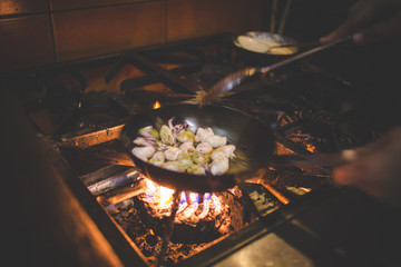 Close up image of a chef preparing a gourmet dish in a rustic restaurant kitchen