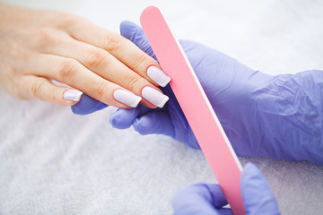 Woman hands in a nail salon receiving a manicure procedure. SPA manicure