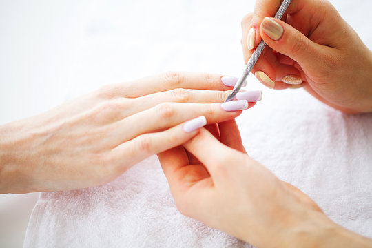 Woman hands in a nail salon receiving a manicure procedure. SPA manicure