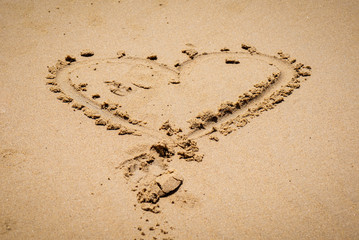 A heart shape made on a sandy beach.