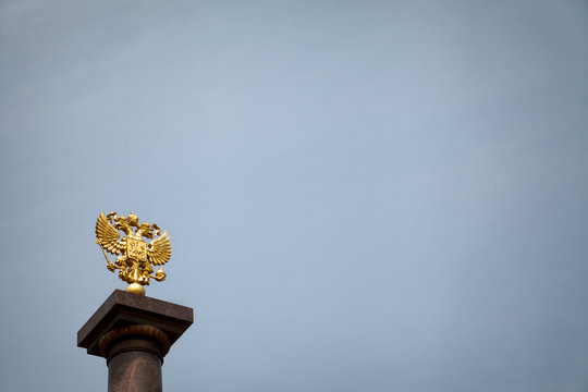 Coat of arms of Russia, golden two-headed eagle against the blue sky. Gold Russian heraldic symbol background with copy space