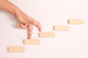 Hand liken business person stepping up  toy staircase