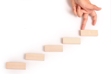 Hand liken business person stepping up  toy staircase