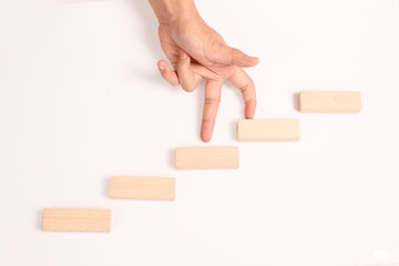 Hand liken business person stepping up  toy staircase
