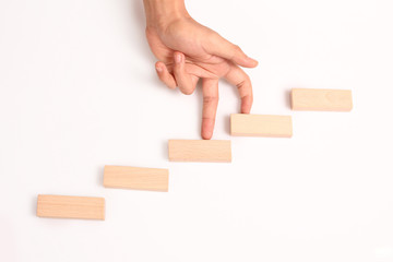 Hand liken business person stepping up  toy staircase