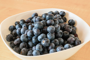 Fresh Polish blueberries in a bowl on a wooden table.