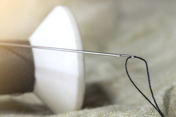 close up of black thread in needle