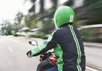 Rear view of motorcycle taxi driver with black and green unifrom