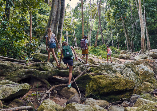 Young caucasian tourists climb the stones in jungle