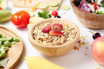 Close up of muesli, mixed vegetables salad and fresh fruits on white background.