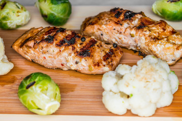 Fried salmon on a blackboard with broccoli, colored and Brussels