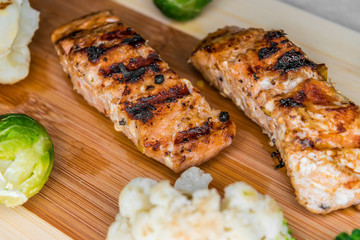 Fried salmon on a blackboard with broccoli, colored and Brussels