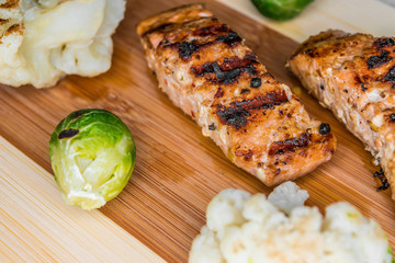 Fried salmon on a blackboard with broccoli, colored and Brussels