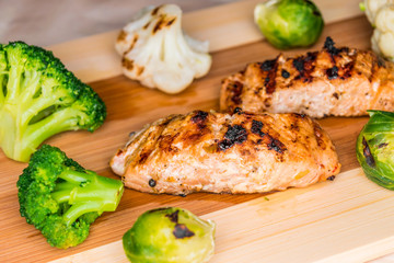 Fried salmon on a blackboard with broccoli, colored and Brussels