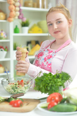 Obraz na płótnie Canvas Cute teen girl preparing fresh salad