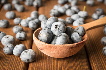 Fototapeta na wymiar Fresh blueberries on an old wooden table in a wooden spoon. Close up. The concept of natural food