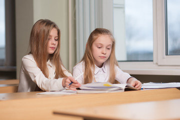 student girls are sitting at a Desk