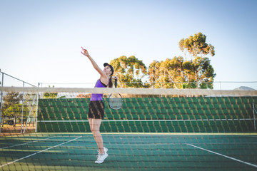 Obraz premium Close up image of a female tennis player playing tennis on a court in bright sunlight