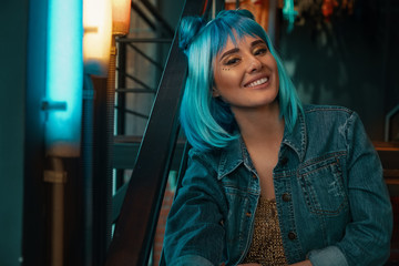 Cheerful girl portrait with stylish blue hair and shiny smile