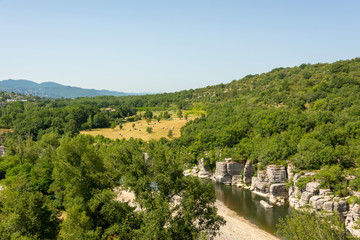 Fototapeta na wymiar Panorama landscape with the river Ardeche, framed by rock faces and a lot of vegetation at 