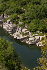 Fototapeta na wymiar View of the river Ardeche, framed by rock faces and a lot of vegetation at 
