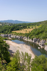 Fototapeta na wymiar Landscape with the river Ardeche, framed by rock faces and much vegetation at 
