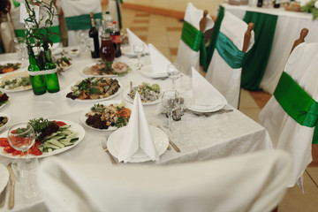 Tasty and delicious food and meals at wedding reception table, beautiful arrangement and white tablecloth, rich dishes and alcohol drinks at restaurant closeup