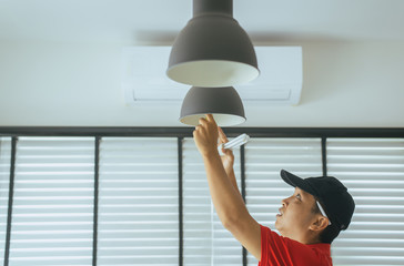 Power saving electrical and efficiency concept,Hands technician compact-fluorescent CFL bulb with...