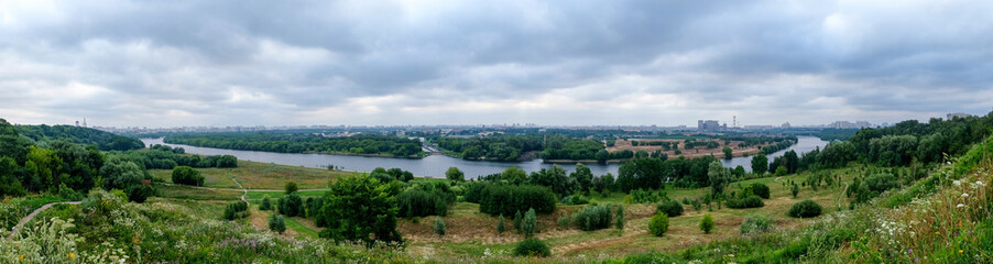 Fototapeta na wymiar Panorama with the river and city buildings on the horizon. Kolomenskoye, Moscow, Russia