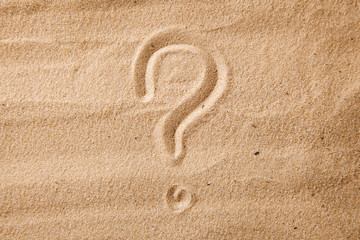 Fototapeta na wymiar The question mark is sand painted on sand. Symbol of choice and doubt