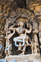 Fototapeta na wymiar Carved figure of a Sundari, beautiful lady, looking in the mirror, Chennakeshava temple. Belur, Karnataka.