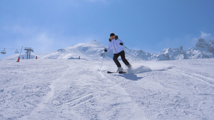 A Woman Skier Carving Go Down The Ski Slope Of The Mountain