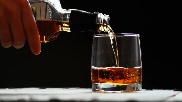 Glass with ice and scotch whiskey on wooden glass