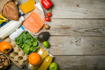 Grocery shopping concept. Balanced diet concept. Fresh foods with shopping bag on rustic wood background
