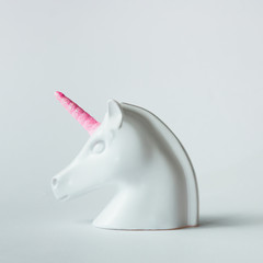 White painted unicorn head with pink horn on bright white background. Minimal art fantasy concept. © Zamurovic Brothers