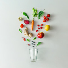 Creative food layout with fruits, vegetables and leaves on bright marble table background with tea cup. Minimal healthy drink concept. Flat lay.