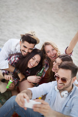 Group of cheerful friends having great time at beach