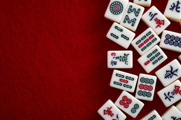 Traditional chinese games and tile based game concept with mahjong pieces isolated on red background with copy space - obrazy, fototapety, plakaty