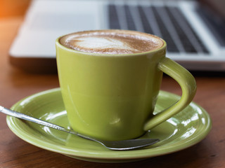 coffee cup and computer laptop on wooden table