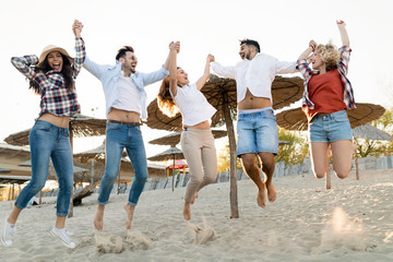 Obraz premium Friends partying and having fun on beach at summer
